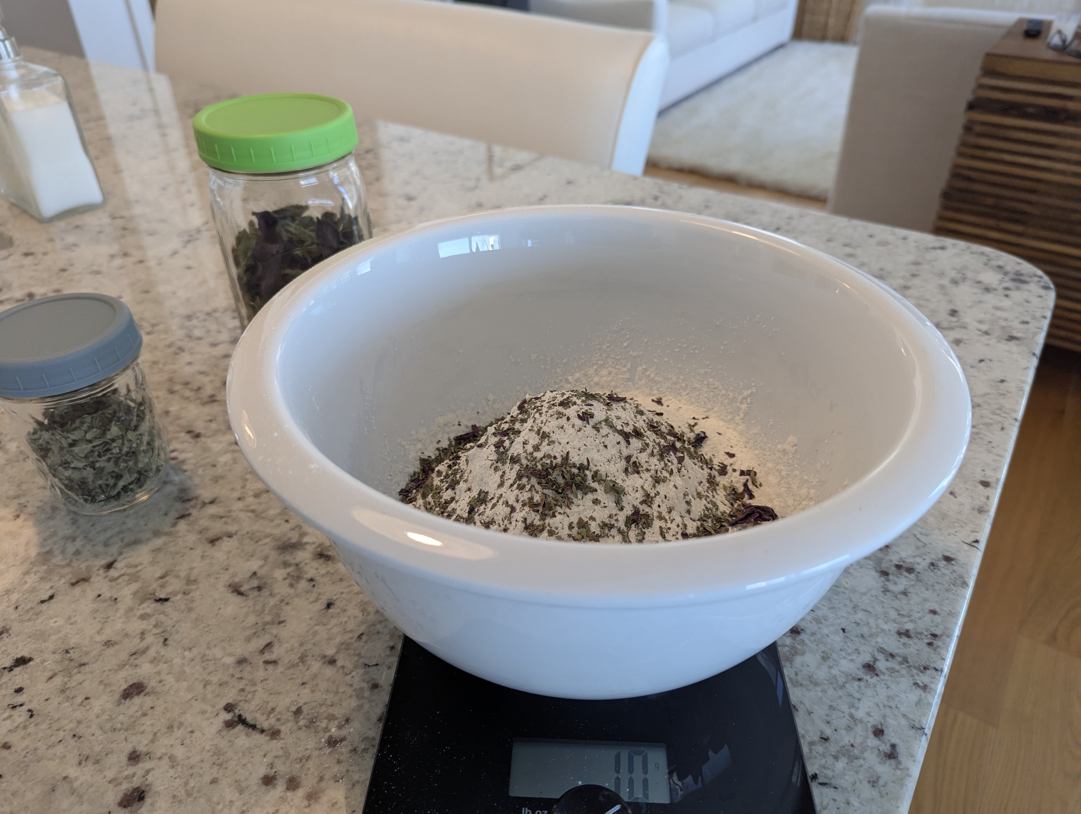 Flour and dried herbs in mixing bowl for no-knead bread