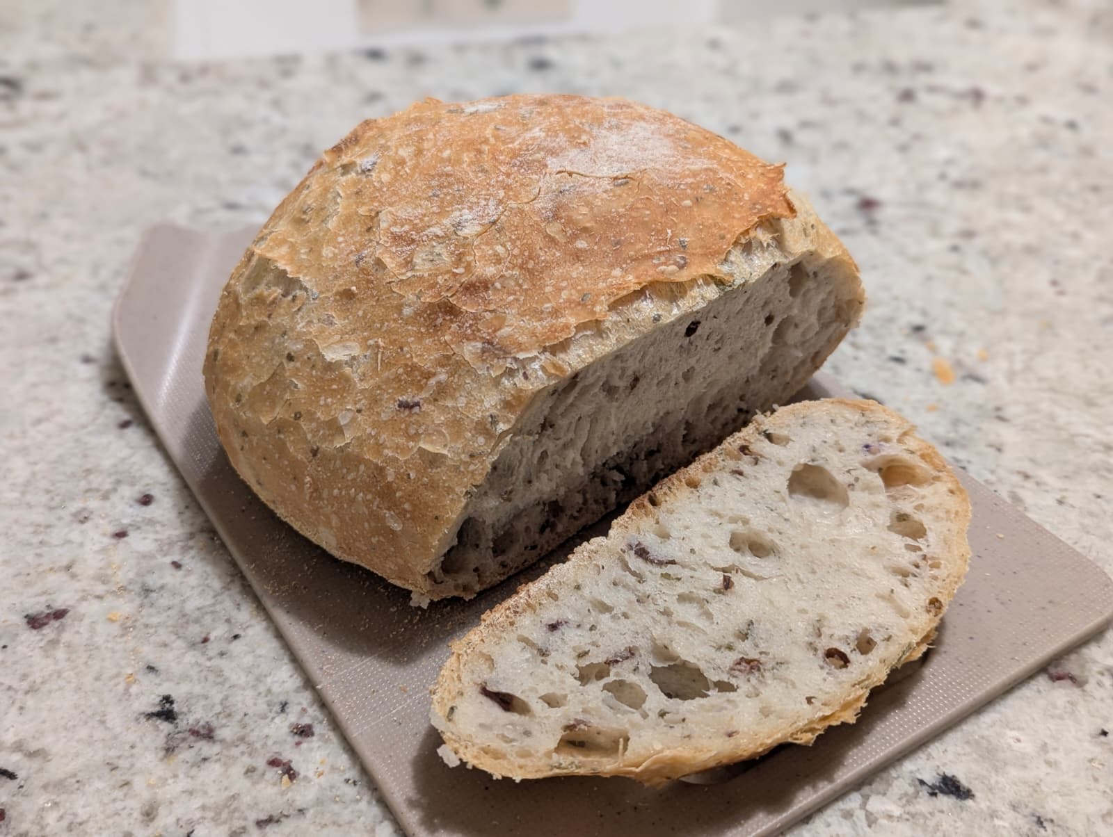 Finished no-knead herb bread loaf with garden oregano and basil