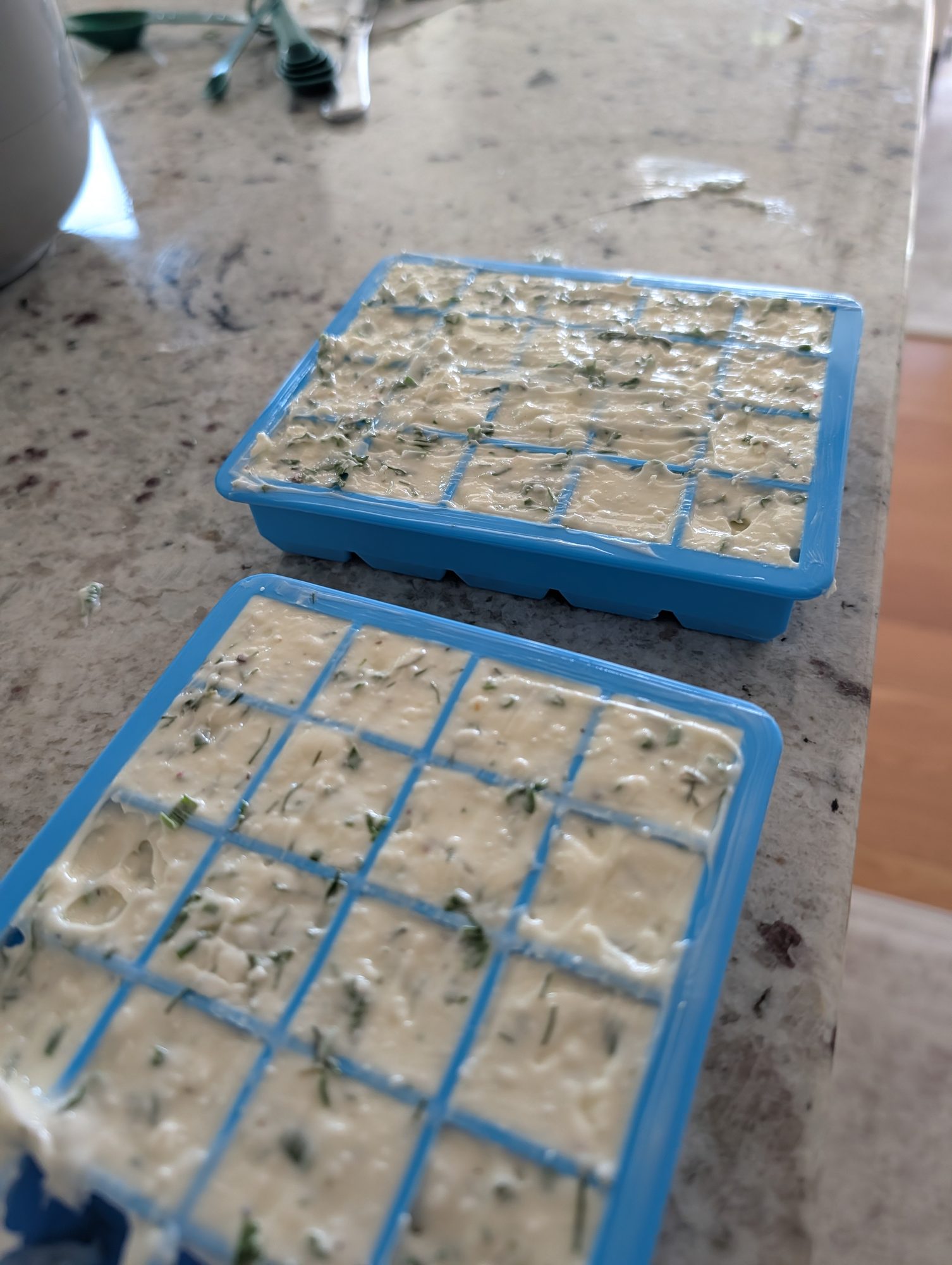 Photo by Chris Izworski, herb butter with thyme, chive, parsley and cracked pepper pressed into blue ice cube trays before freezing at Freighter View Farms near Saginaw Bay, Bay City, Michigan